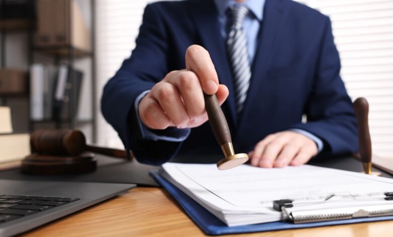 notar care stampileaza un document in birou