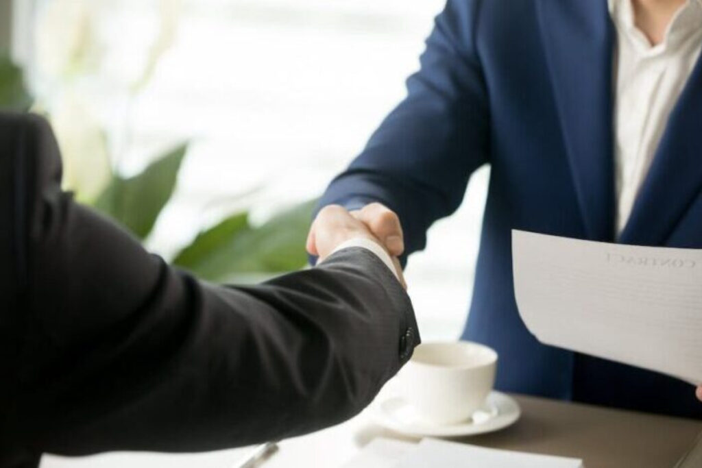 barbati care dau mana la semnarea contractului de cesiune