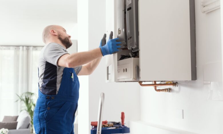 Barbat care instaleaza un boiler pe gaz acasa