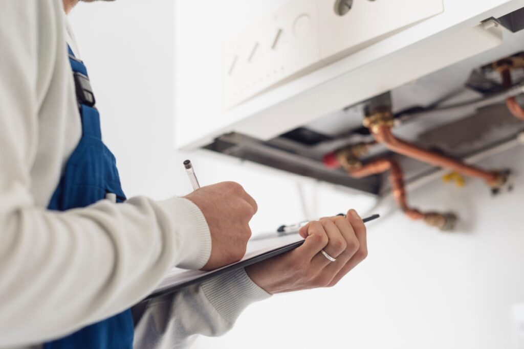 Instalator profesional care verifica un boiler pe gaz