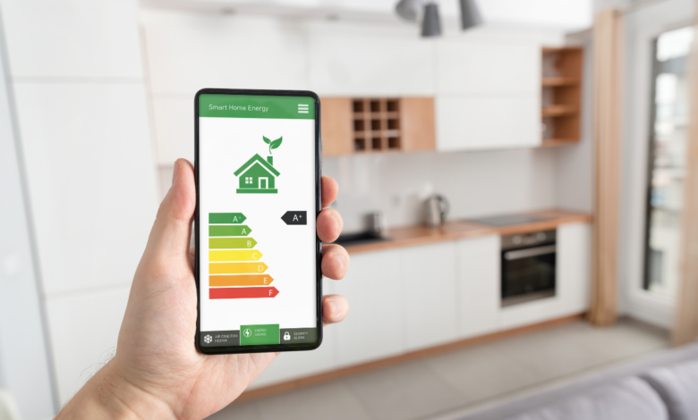 barbat care tine in mana un telefon cu aplicatie smart home pentru reducerea consumului de energie